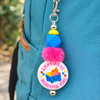 Coping Life handmade fidget keychain with colorful beads and pom-pom charm clipped to teal pants belt loop